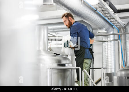 Uomo che lavora alla birreria artigianale o impianto di birra Foto Stock