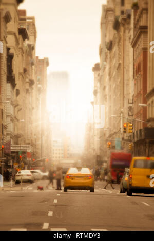 La luce del sole splende su New York City strada urbana con anonimo sfocato persone, automobili e giallo taxi Foto Stock