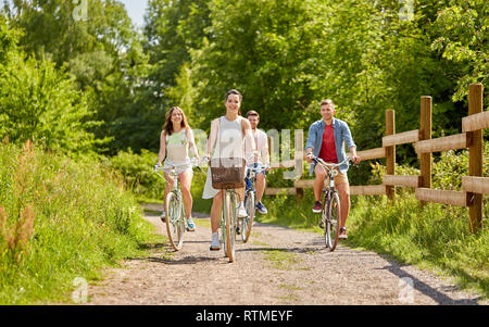 Happy amici di equitazione ingranaggio fisso di biciclette in estate Foto Stock