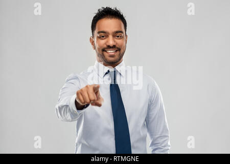 Commerciante indiano in camicia con cravatta su grigio Foto Stock