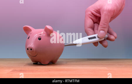 Simbolo per l'influenza suina o simbolo di non avere i soldi. Mano trattiene un termometro per un salvadanaio. Foto Stock