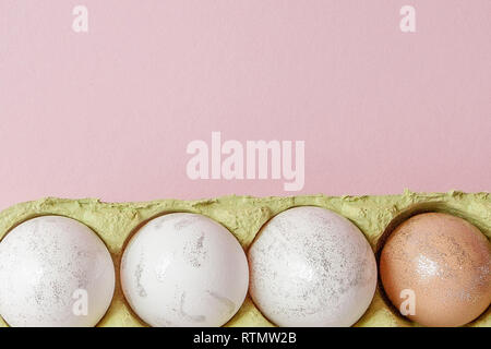 Bianco uova di Pasqua nella casella su sfondo rosa con copia spazio. Foto Stock