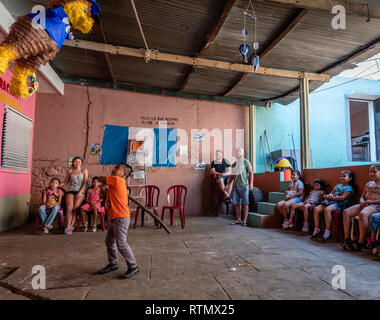 Giovane ragazzo latino swinging a pinata a Guatemala festa di compleanno Foto Stock