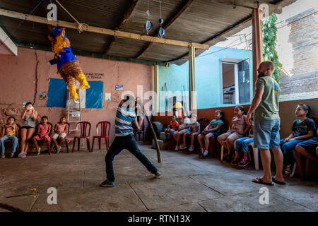 Giovane ragazzo latino swinging a pinata a Guatemala festa di compleanno Foto Stock