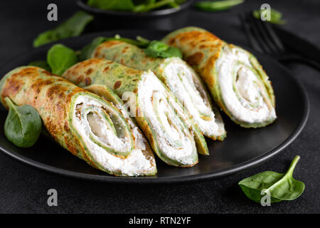 Crepes salate con spinaci e formaggio feta su sfondo nero Foto Stock