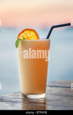 La pina colada cocktail close-up sulla spiaggia al tramonto in Thailandia Foto Stock