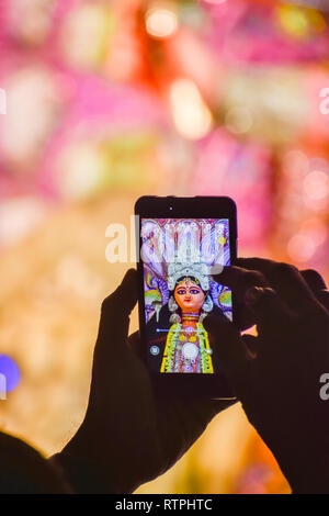 La cattura di fotografia di Durga idolo con telefono cellulare durante la durga puja festival in Kolkata. Foto Stock