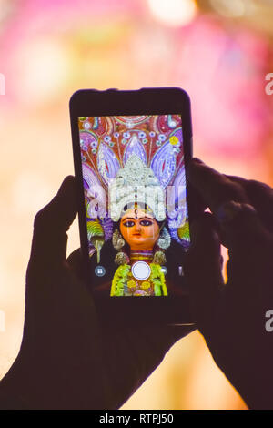 La cattura di fotografia di Durga idolo con telefono cellulare durante la durga puja festival in Kolkata. Foto Stock