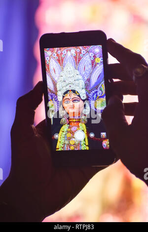 La cattura di fotografia di Durga idolo con telefono cellulare durante la durga puja festival in Kolkata. Foto Stock