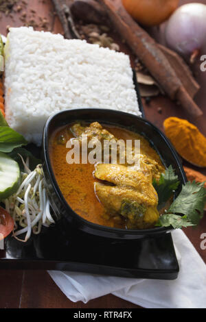 Vista laterale di un pollo al curry, è un cibo fatto dal pollo imbevuto con erbe e salsa di spezie, presentando con aumento, i germogli di soia, pomodoro, cetriolo, auto Foto Stock