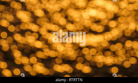 Luccicante e scintillante di giallo e arancione sfocata superficie dell'oceano al tramonto con sole riflessioni su di esso Foto Stock