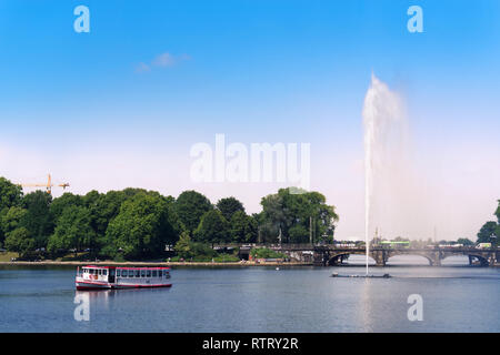 Amburgo, Germania - 26 Giugno 2018: Escursione nave e una fontana sul lago Alster come un mondo di famosi punti di riferimento di Hamburg city center Foto Stock