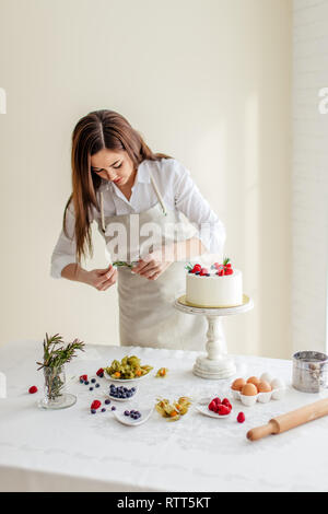 Bella ragazza azienda verde per decorare il dessert, close up foto Foto Stock