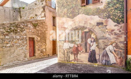 Sardegna Italia su dicembre 27, 2019: murales dipinti sulle case per le strade di Tinnura raffiguranti momenti di zone rurali e la vita del villaggio Foto Stock