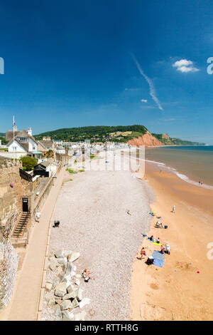 Guardando verso est lungo la promenade e clifftop case verso le rosse scogliere di arenaria su Jurassic Coast a Sidmouth, nel Devon, Inghilterra, Regno Unito Foto Stock