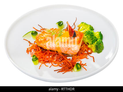 Delizioso SALMONE ARROSTO sul cuscino di carote affumicato servita con verdure fresche sulla piastra. Isolato su sfondo bianco Foto Stock