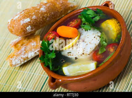 Far bollire il pollock testa per il brodo. Aggiungere le patate, carote, scalogno, mais e filetti o bistecca pollack 200 gramm, sale, pepe. Portare il forno nel Foto Stock