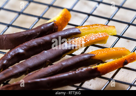 Immagine macro di casa fatta di scorza d'arancia candita immersi nel cioccolato Foto Stock