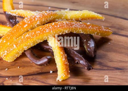 Immagine macro di casa fatta di scorza d'arancia candita alcuni pezzi immersi nel cioccolato Foto Stock