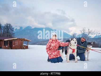 Ragazza con i cani in inverno in montagna Foto Stock