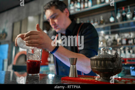 Il barista versa un cocktail presso il bar Foto Stock