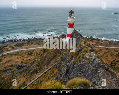 Guardando verso il basso su 2 persone, arrampicate ripide lunga fila di scale, fino a Cape Palliser faro, Palliser Bay, Wairarapa, Nuova Zelanda Foto Stock