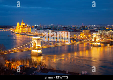 La notte scende sul Danubio a Budapest, il Ponte della Catena e il parlamento ungherese nella distanza. Foto Stock