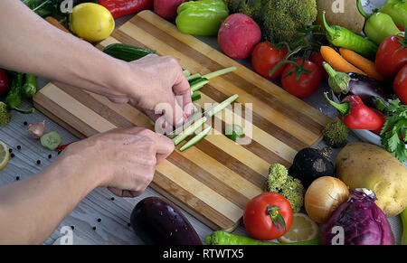 L uomo è il taglio di vegetali in cucina, Affettare cetrioli Foto Stock