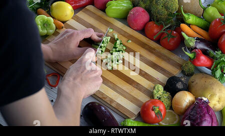 L uomo è il taglio di vegetali in cucina, Affettare cetrioli Foto Stock