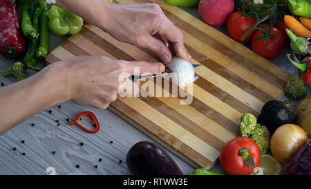 L uomo è il taglio di vegetali in cucina, affettare la cipolla Foto Stock