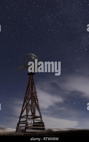 Un mulino a vento blade spin su una solitaria notte nel cuore del Wyoming Foto Stock