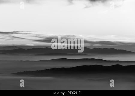 La nebbia di riempimento di una valle in Umbria (Italia), con strati di montagne e colline Foto Stock