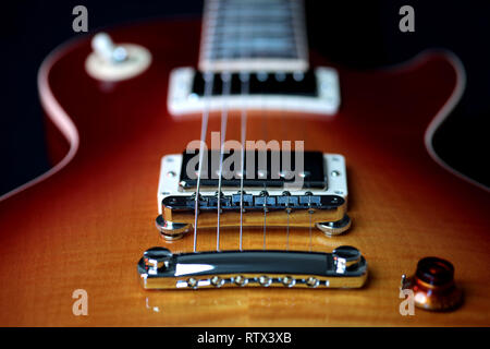 Immagine ravvicinata di una chitarra elettrica corpo, bridge pick up, cordiera e stringhe Foto Stock