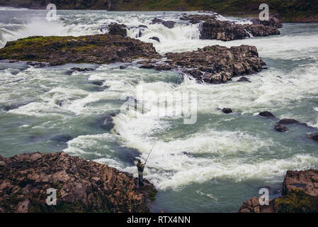 L'uomo la pesca vicino alla cascata Urridafoss situato nel fiume Thjorsa nel sud-ovest dell'Islanda Foto Stock
