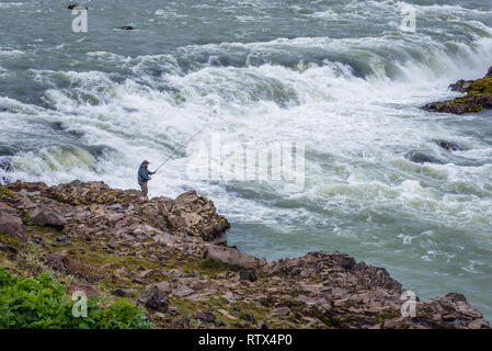 L'uomo la pesca vicino alla cascata Urridafoss situato nel fiume Thjorsa nel sud-ovest dell'Islanda Foto Stock