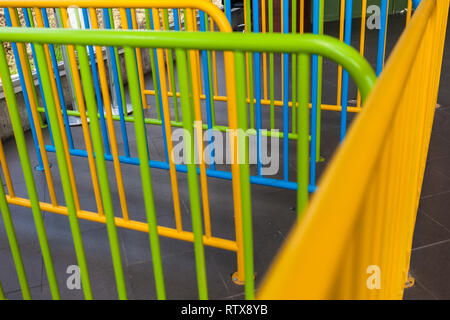 Tubi corrimano verniciati in giallo, verde, blu Foto Stock