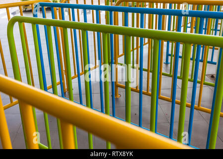 Tubi corrimano verniciati in giallo, verde, blu Foto Stock