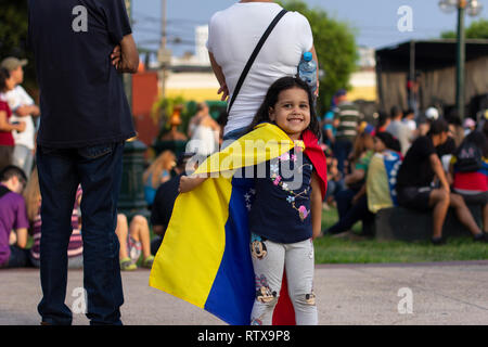 Lima in Perù - 2 Febbraio 2019: carino adorabile bambina gioca con bandiera venezuelana a protestare contro Nicolas Maduro a sostegno di Juan Guaido Foto Stock