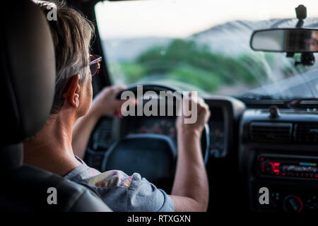 Adulta signora caucasica la guida e guardando la strada davanti - concetto di viaggiare con auto e avere cura - assicurazione per le femmine - Foto Stock