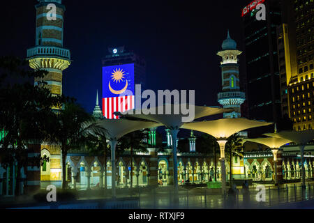 Masjid Jamek (Jamek Moschea) di notte, Kuala Lumpur, Malesia. Bandiera malese in background. Foto Stock