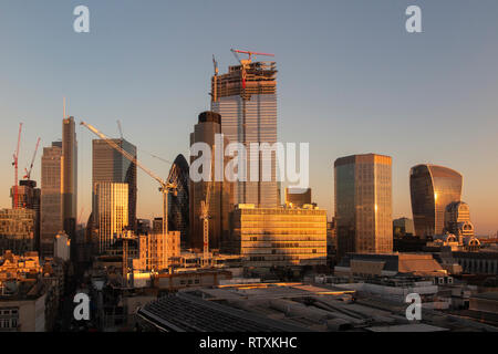 Un drammatico City of London skyline con gli alti edifici immersi nella luce dorata Foto Stock