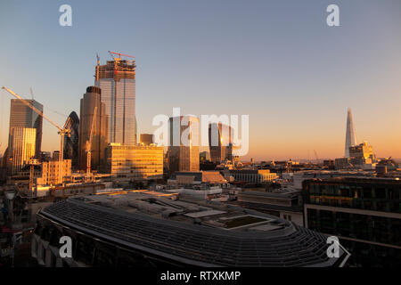 Un drammatico City of London skyline con gli alti edifici immersi nella luce dorata Foto Stock