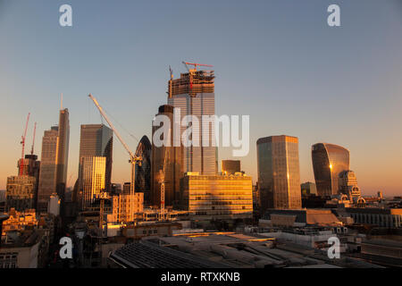 Un drammatico City of London skyline con gli alti edifici immersi nella luce dorata Foto Stock