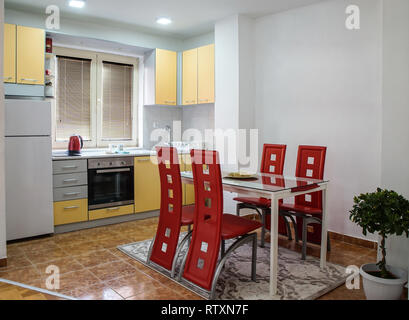 Moderna cucina con zona pranzo con belle sedie di pelle rossa Foto Stock