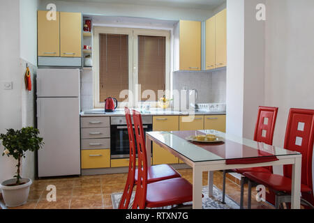 Moderna cucina con zona pranzo con belle sedie di pelle rossa Foto Stock