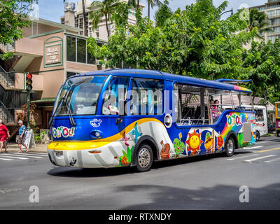 Colorato autobus turistico su Kalakaua Avenue in Waikiki on April 29, 2014. Gli autobus turistici sono un popolare bus navetta che porta i turisti intorno a scenic Waikik Foto Stock