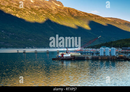 Settembre 15, 2018 - Skagway AK: Broadway Dock cargo industriale wharf con rimorchiatore a traino e gru a sunrise. Foto Stock