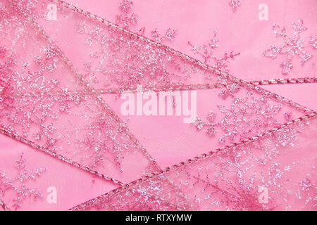 Un abstract texture di sfondo close up dettaglio in un Natale nastro rosa glitter con i fiocchi di neve Foto Stock