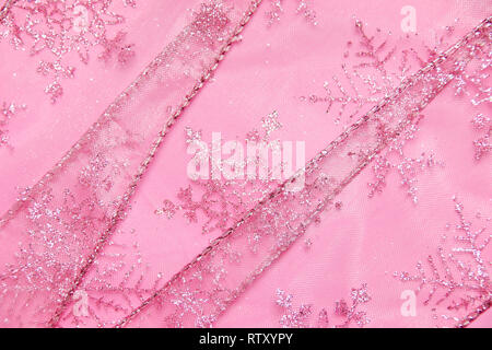 Un abstract texture di sfondo close up dettaglio in un Natale nastro rosa glitter con i fiocchi di neve Foto Stock