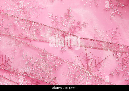 Un abstract texture di sfondo close up dettaglio in un Natale nastro rosa glitter con i fiocchi di neve Foto Stock